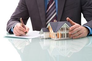 Man with model home signing a contract